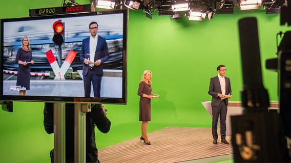 Zwei Fernsehmoderatoren stehen in einem digitalen Studio vor einem grünen Hintergrund. © NDR Foto: Janis Röhlig