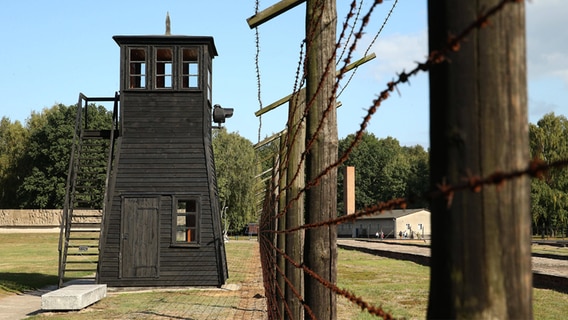Blick entlang eines Stacheldrahtzauns auf das ehemalige Konzentrationslager Stutthof © Imago 