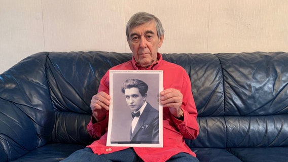 Josef Salomonovic hält ein Fotos seines Vaters in den Händen. © NDR Foto: Corinna Below