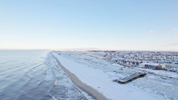 Eine Drohnenaufnahme zeigt eine verschneite Küste auf der Nordseeinsel Sylt. © Studio Sylt - Georg Heimberger 