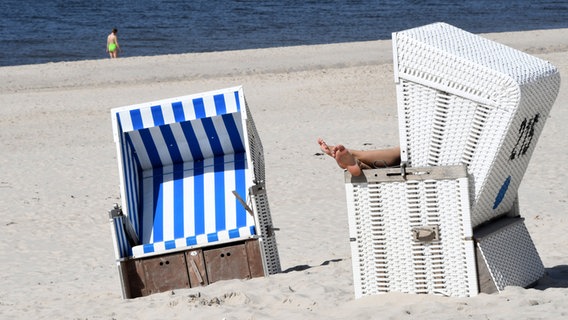 Sylt: Eine Frau sitzt in einem Strandkorb. © dpa Foto: Lea Sarah Albert
