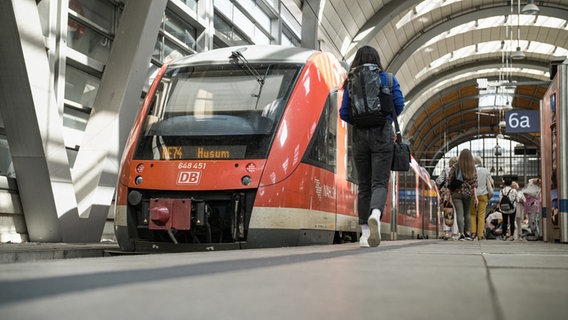 Dere Zug nach Husum steht am Gleis. Reporterin Lisa läuft den Bahnsteig runter. © NDR Foto: Dominik Dührsen