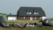 In der Nähe eines Wohnhaus liegen Teile eines Tornado Kampfflugzeuges © picture-alliance / dpa/dpaweb Foto: Carmen jaspersen