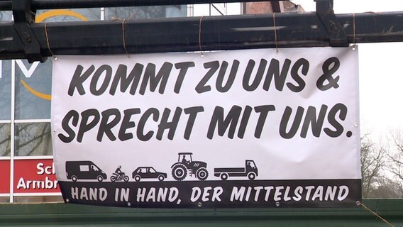 Auf einem Plakat steht "Kommt zu uns & sprecht mit uns". © NDR 