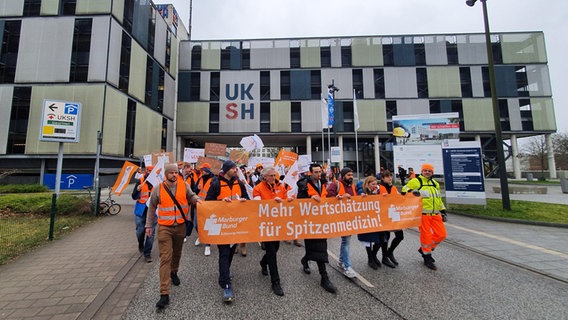 Vor dem UKSH in Kiel streiken die Beschäftigten. Auf einem Transparent steht "Mehr Wertschätzung für Spitzenmedizin". © NDR Foto: Carsten Salzwedel
