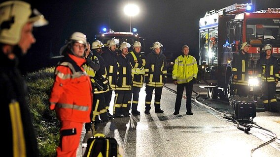 Schockierte Feuerwehrleute am Einsatzwagen. © Karsten Sörensen Foto: Karsten Sörensen