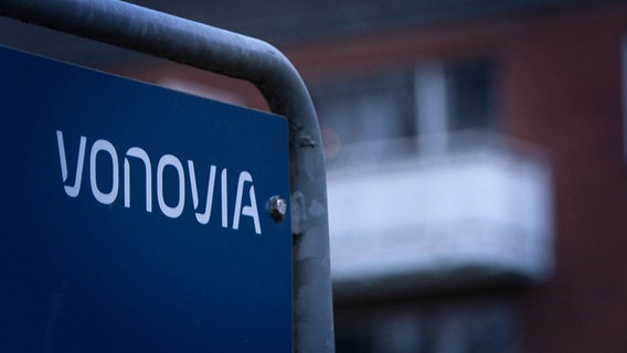 Schriftzug Vonovia steht an einem Schild vor einem Mehrfamilienhaus in Lübeck. © NDR 