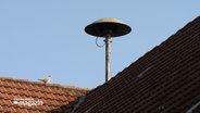 Auf einem Dach ist eine Sirene installiert. © NDR 