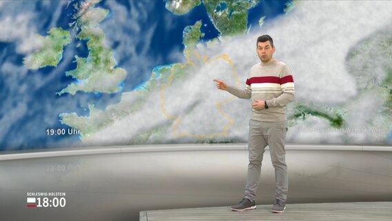 NDR Moderator Sebstian Wache steht im Studio mit der Wettervorhersage. © NDR 