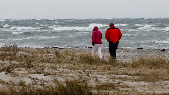 Zwei Personen gehen am Strand spazieren. © dpa-Bildfunk Foto: Frank Molter