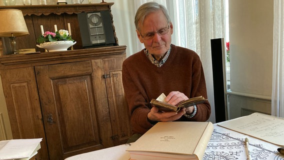 Ein älterer Herr liest in seinem Wohnzimmer ein Buch. © NDR Foto: Philip Schroeder