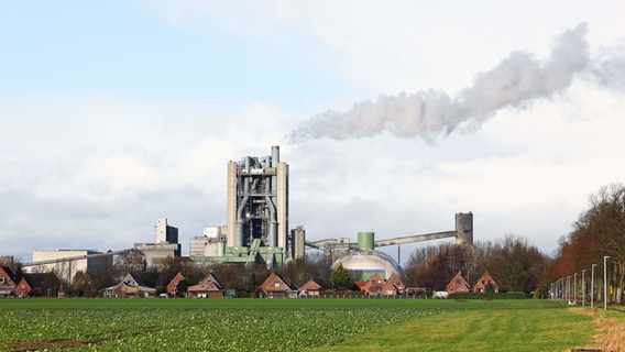 Der Ofen des Zementwerks von Holzim überragt die Häuser am Ortsrand von Lägerdorf. © dpa-Bildfunk Foto: Christian Charisius