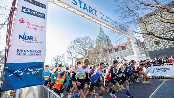 Marathoni laufen durch den Torbogen beim Hannover-Marathon 2022. © eichels: Event GmbH 