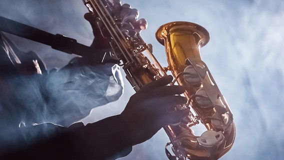 Ein Saxofon-Spieler spielt in einem Club © fotolia.com Foto: GeoffGoldswain