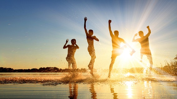 Junge Leute springen ins Wasser an einem See © Fotolia.com Foto: Thaut Images