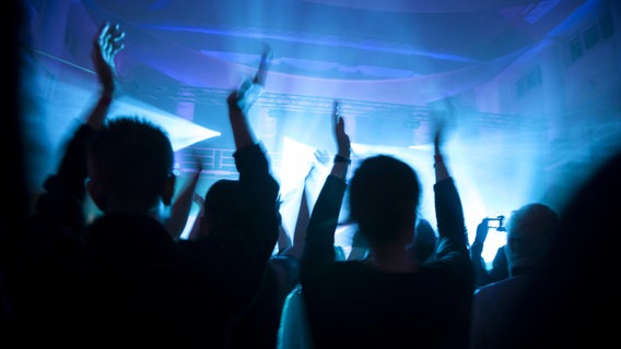 Menschen tanzen in einem Club. © IMAGO / Westend61 