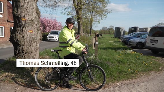 Thomas Schmelling steht mit seinem Fahrrad an einer Straße. © NDR 