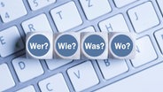 Spielsteine mit den Fragewörtern liegen auf einer Tastatur. © fotolia.com Foto: fotogestoeber