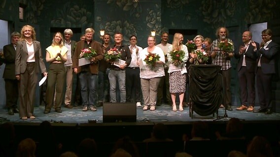 Sieger des plattdeutschen Wettbewerbs Vertell doch mal stehen nebeneinander auf einer Bühne. © NDR 