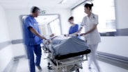 Arztteam rollt Patient auf Klinikbett durch einen Krankenhausflur. © panthermedia Foto: spotmatikphoto