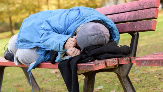 Ein Obdachloser liegt auf einer Bank. © Michael Heim Foto: Michael Heim