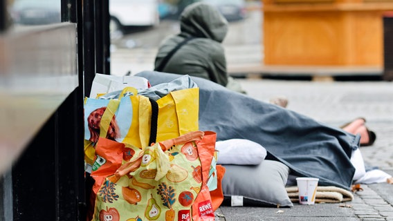 Einkaufstüte und das Schlaflager eines Wohnungslosen in Kiel. © picture alliance / dpa Foto: Frank Molter