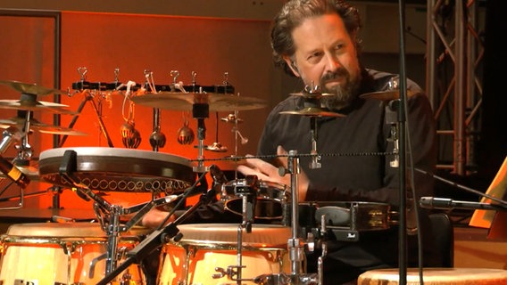 Percussionist Marcio Doctor und die NDR Bigband spielen beim Konzert "Fusion - Conclusion". © NDR Bigband Foto: Screenshot