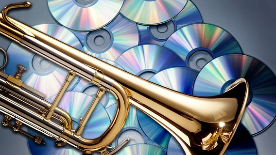 Eine Trompete liegt auf einen Haufen CDs (Bildmontage) © Fotolia Foto: Sscalaphotography, Spectral-Design