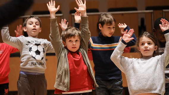 Szene aus einem Familienkonzert im Rolf-Liebermann-Studio des NDR: Kinder hüpfen mit erhobenen Händen © NDR Foto: Marcus Krüger