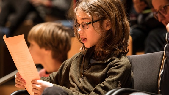 Szene aus einem "Konzert statt Schule" im Rolf-Liebermann-Studio: Ein Kind im Publikum singt konzentriert und mit Hingabe. © NDR Foto: Marcus Krüger