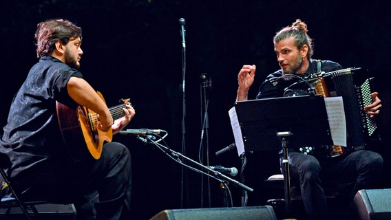 Die Musiker Yamandu Costa und Vincent Peirani bei einem Auftritt auf der Bühne. © NDR Jazz/JL Neveux Foto: JL Neveux