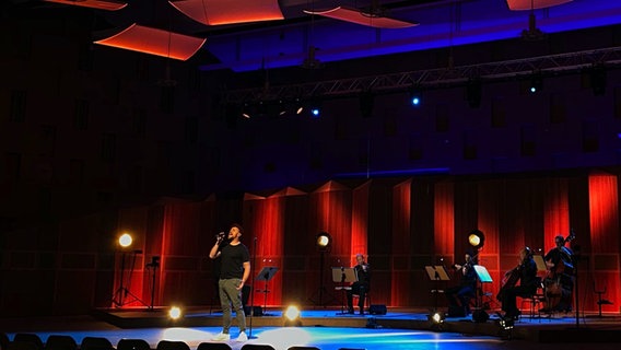 Screenshot Max Mutzke und Musiker der NDR Radiophilharmonie auf der Bühne des Großen Sendesaals © NDR Foto: Fabian Döring