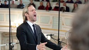 Eric Whitacre dirigiert mit großer Geste und engagiertem Gesichtsausdruck. © NDR Foto: Dirk Uhlenbrock