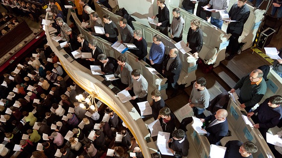 Blick von oben: Sänger mit Notenblättern auf der Empore und unten im Kirchenschiff © NDR Foto: Dirk Uhlenbrock