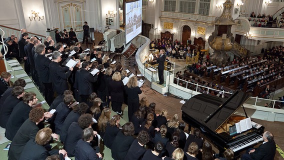 Konzertszene: Blick von oben über Sänger, Dirigent und Zuschauer auf Empore und Kircheninnenraum © NDR Foto: Dirk Uhlenbrock