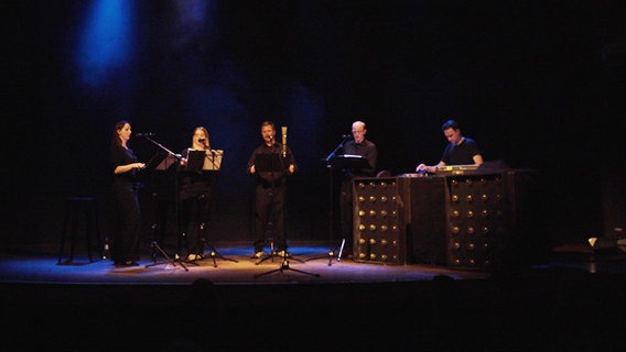 Screenshot: Mitglieder des NDR Vokalensembles singen im Hamburger Mojo Club - mit auf der Bühne: DJ Martin Stimming. © NDR Vokalensemble Foto: Screenshot