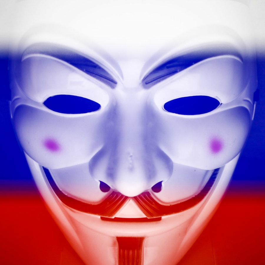 Eine Guy Fawkes Maske vor einer russischen Flagge. © picture alliance / NurPhoto | Jakub Porzycki 