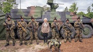 Bundesverteidigungsministerin Christine Lambrecht (SPD) steht bei ihrem Auftakt-Besuch ihrer Sommerreise auf dem Truppenübungsplatz Munster zwischen bewaffneten Grenadieren. © picture alliance/dpa | Mohssen Assanimoghaddam Foto: Mohssen Assanimoghaddam