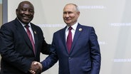 Wladimir Putin, Präsident von Russland, und Cyril Ramaphosa, Präsident von Südafrika, geben sich am Rande des Russland-Afrika-Gipfels die Hände. © picture alliance Foto: Mikhail Metzel