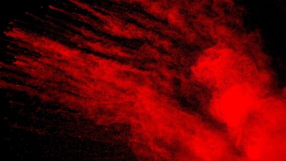 Rotes Pulver Explosion auf schwarzem Hintergrund. © picture alliance / Zoonar | Pattadis Walarput Foto: Pattadis Walarput