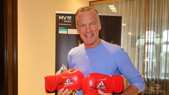 Henry Maske präsentiert seine unterschriebenen Boxhandschuhe. © Signierte Boxhandschuhe Foto: Steffen Holz