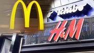 Drei Logos sind im Bild zu sehen. Links das Logo von McDonalds, rechts oben das Logo von Tchibo und links unten das Logo von H&M. © NDR 