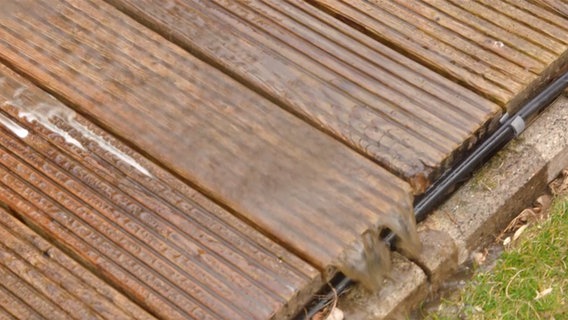 Wasser läuft von gereinigten Holzdielen. © NDR Foto: Udo Tanske