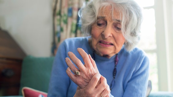 Eine ältere Frau hält sich die schmerzende Hand. © Colourbox 