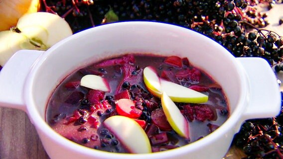 Holunderbeersuppe garniert mit Apfelstückchen.  