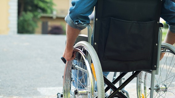 Ein Rollstuhlfahrer ist auf der Straße unterwegs. © Fotolia.com Foto: Minerva Studio