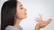 Frau inhaliert den Duft einer Lilie © colourbox Foto: -