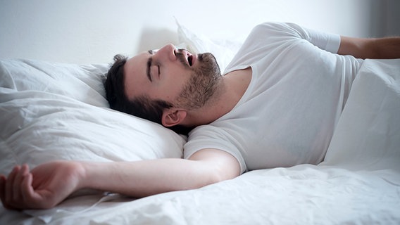 Schlafender Mann im Bett mit geöffnetem Mund. © Fotolia.com Foto: Paolese