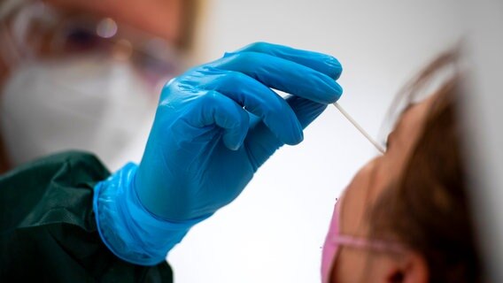 Eine Frau wird in einem Testzentrum auf das Coronavirus getestet. © picture alliance / dpa Foto: Christophe Gateau
