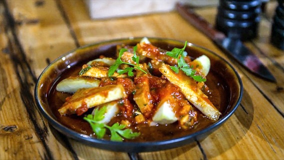 Geräucherter Tofu in Tomatensoße auf einem Teller angerichtet. © NDR 